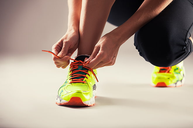 Person tying running shoe
