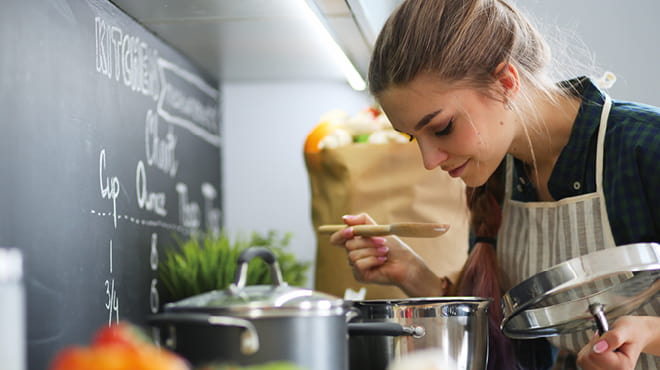 Young woman tasting while cooking