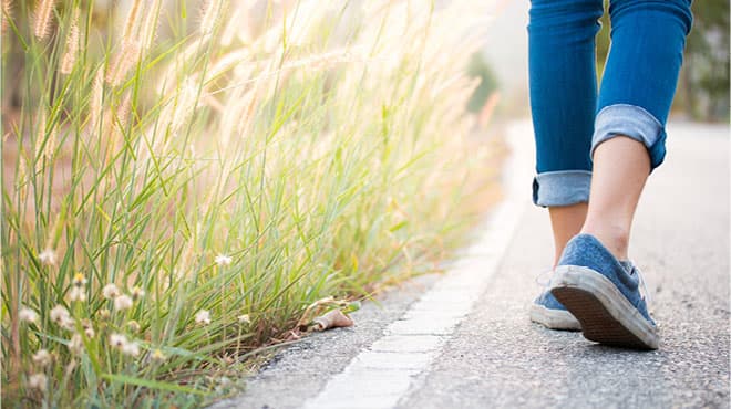 Feet walking trail by prairie grass