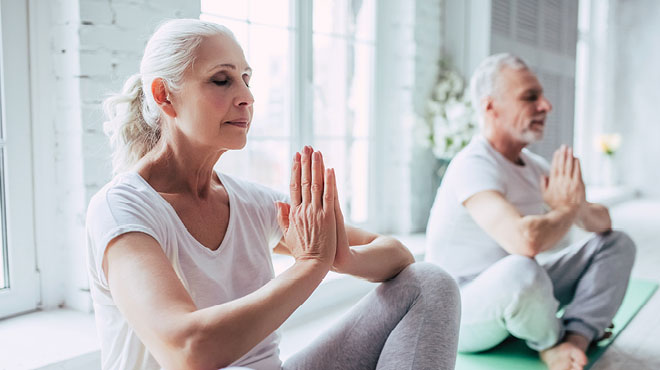 Mature couple folded hands meditation