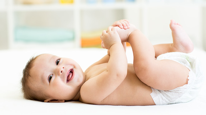 Baby laying on back smiling