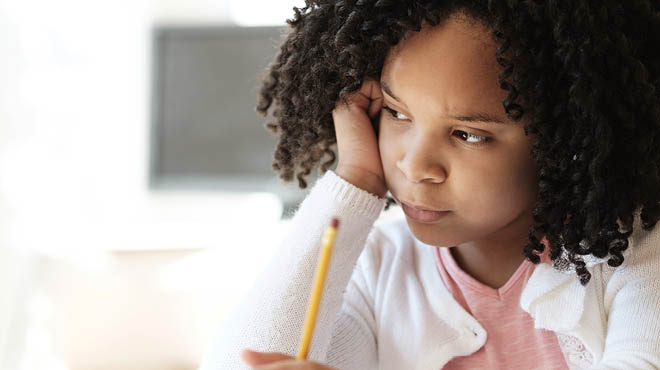 Child holding pencil, resting head on hand, curly hair