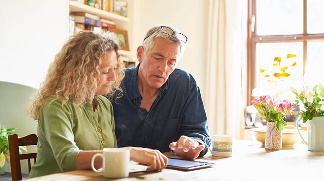 Couple looking at tablet on table