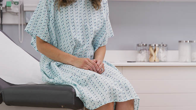 Gowned person on clinic exam table