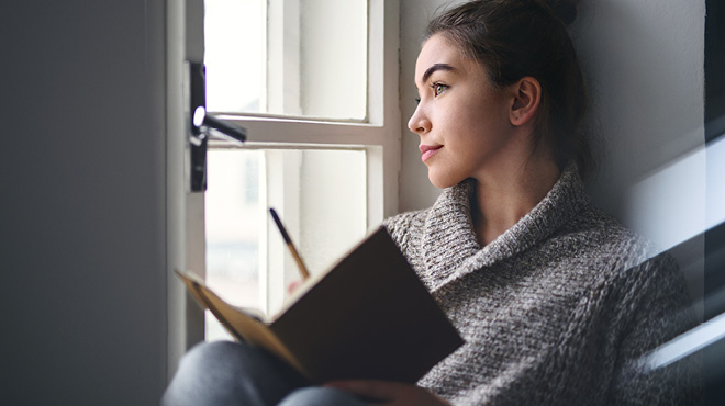 Person journaling while sitting and contemplating