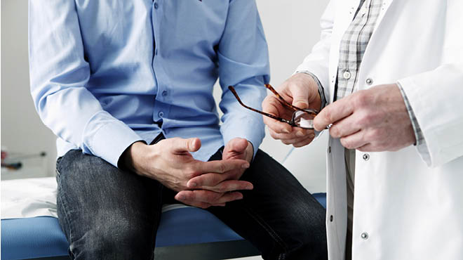 Man sitting on exam table talking to doctor