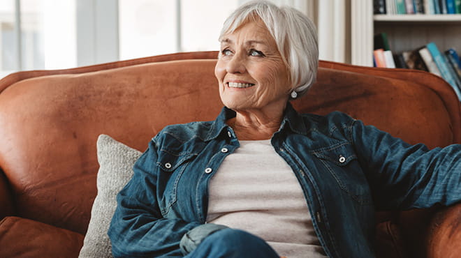 Mature person wearing a denim shirt sitting on a leather chair