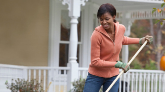 Raking lawn wearing gloves