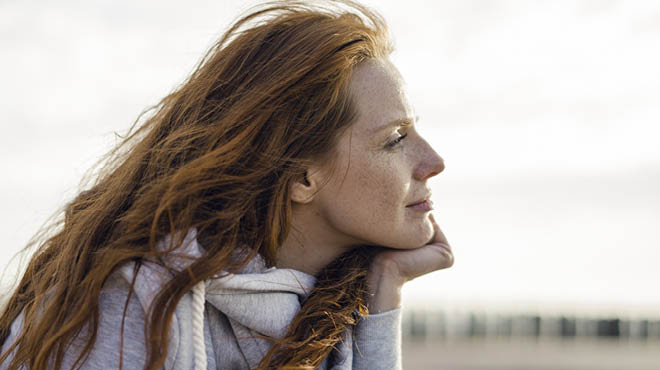 Redhead resting head on hand