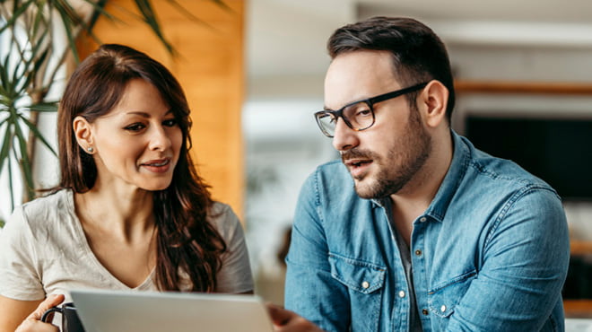 Two people talking looking at laptop