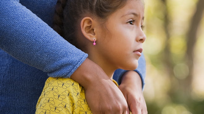 Adult with arms over childs shoulders