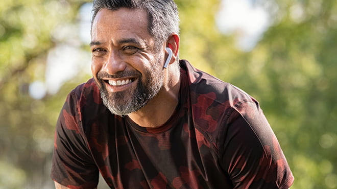 Person with Airpod in ear, salt and pepper hair