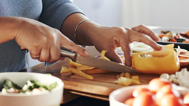 Cutting yellow pepper on board