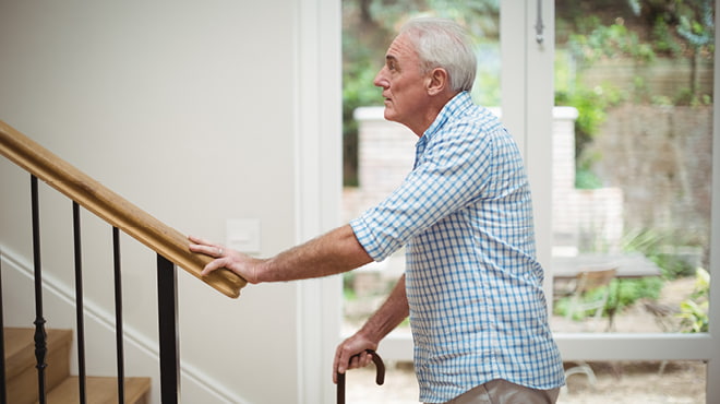 Senior with cane on staircase