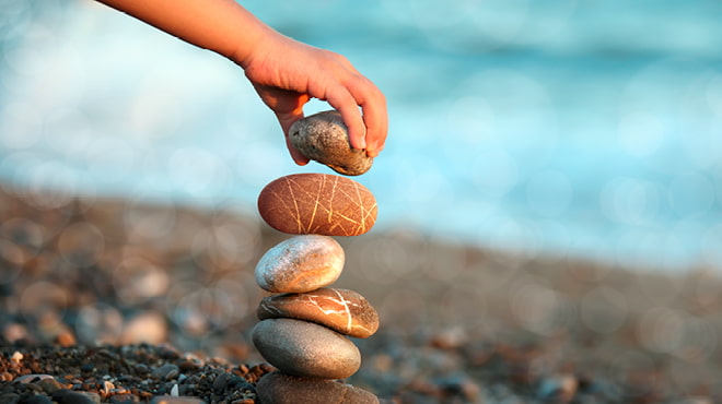 Stone stacking near body of water