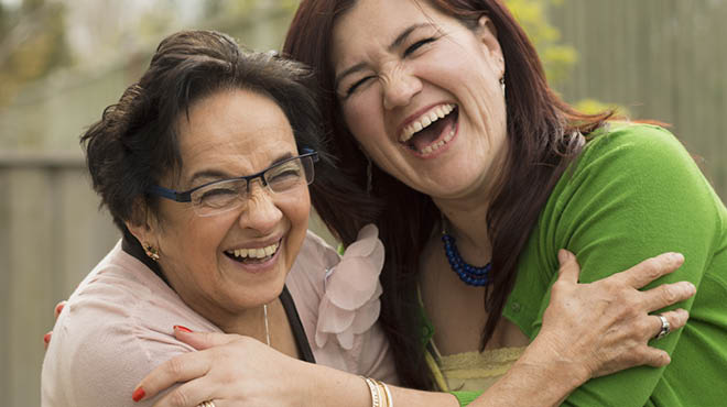 Two people side hugging and laughing