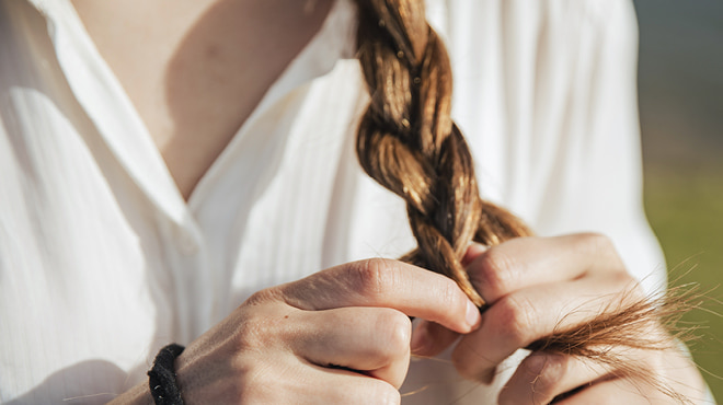 Hands braiding long hair