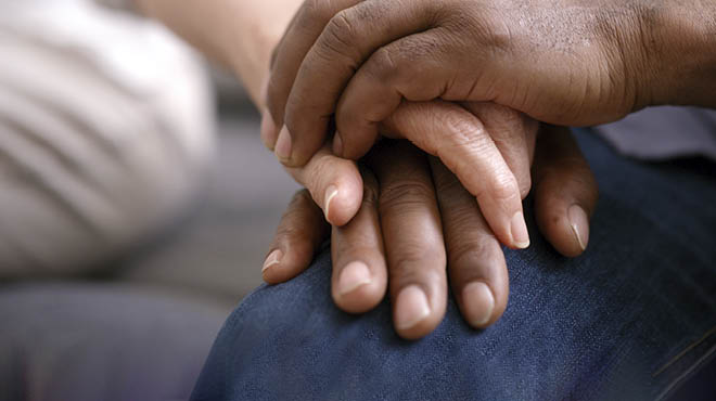 Couple holding hands resting on partner's leg