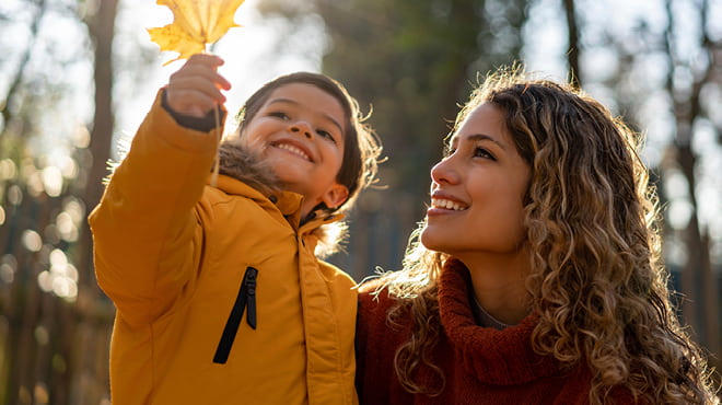 Parent holding child with fall leaf