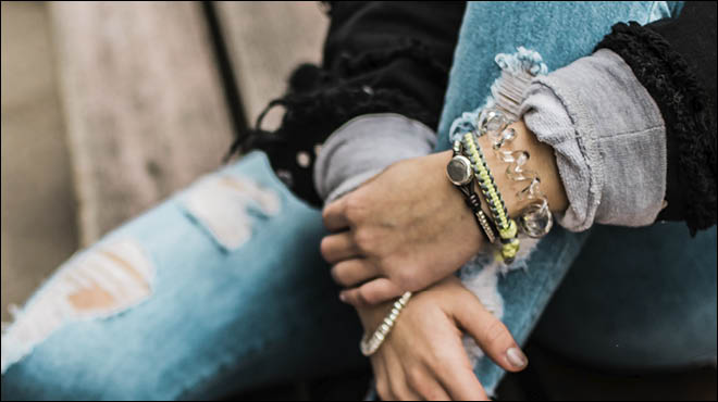 Teen sitting with leg up, hands crossed over shin