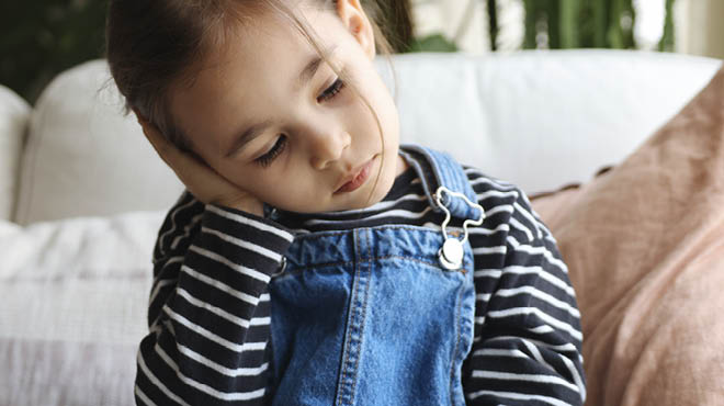 Young child with hand over ear