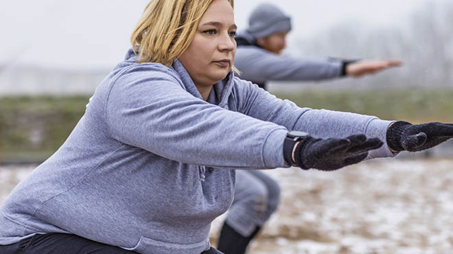 Adult stretching in outdoor wilderness area.